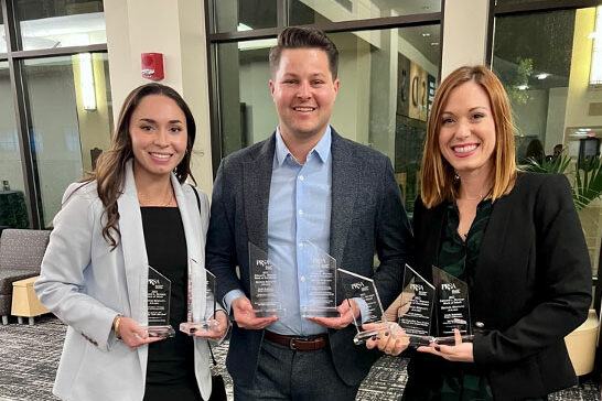 Summer Patton, Kenneth Moore and Chelsey Kamen are smiling while holding awards.